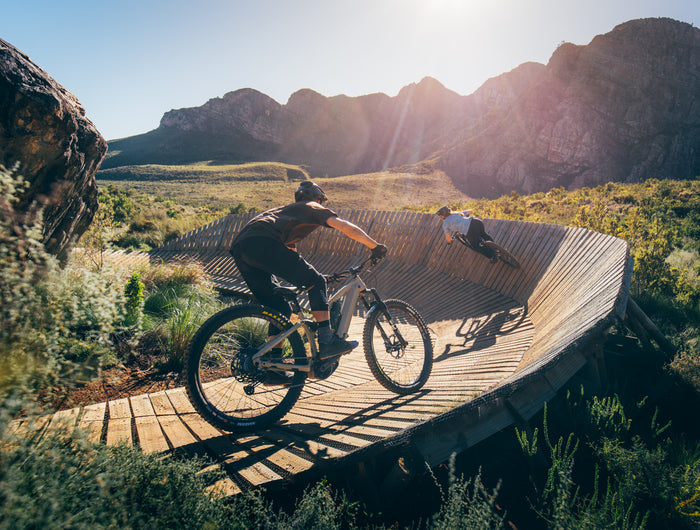 Outer Cycles ebikes riding wooden wallride at Banhoek Conservancy